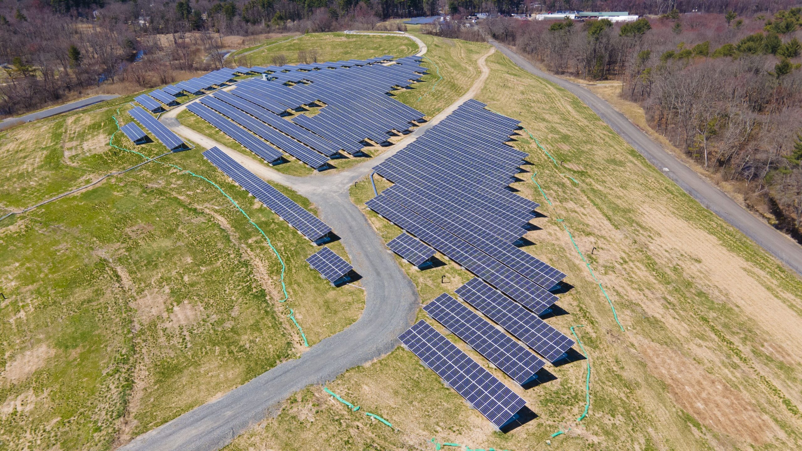 Syncarpha's Tewksbury Landfill Solar Project: Syncarpha's Tewksbury Landfill Solar project is a ballast-mounted, community solar garden constructed in Tewksbury, Massachusetts on the 50-acre Sutton Brook Disposal Area also known as “Rocco Landfill”. The project became operational in February 2022 and provides clean energy to the City of Everett, Tufts University, and local National Grid residents. The project produces enough clean energy annually to power about 400 homes, equivalent to avoiding harmful CO2 emissions from about 3.5 million pounds of coal burned.